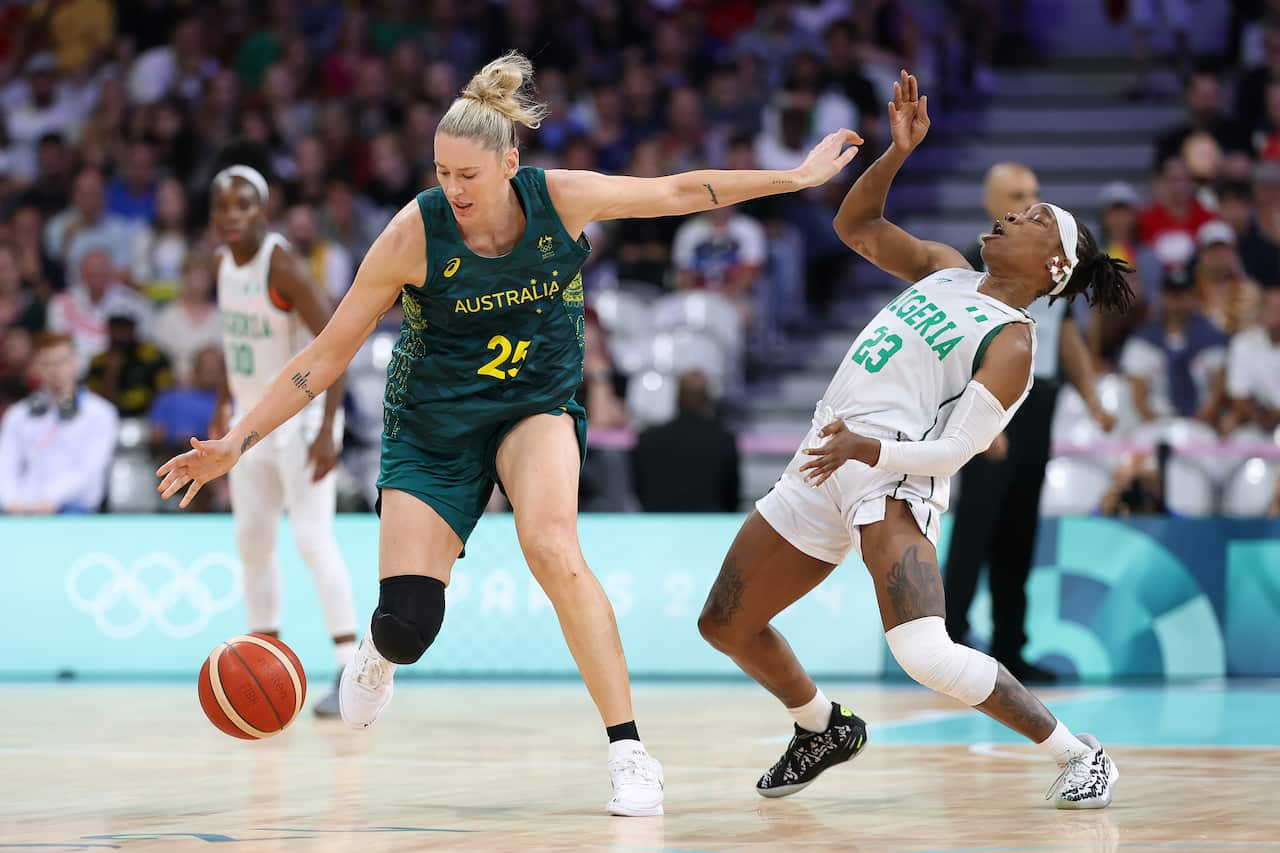 A woman in a green uniform playing basketball