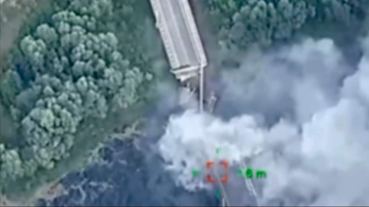 A blurry aerial photo of a bridge being blown up