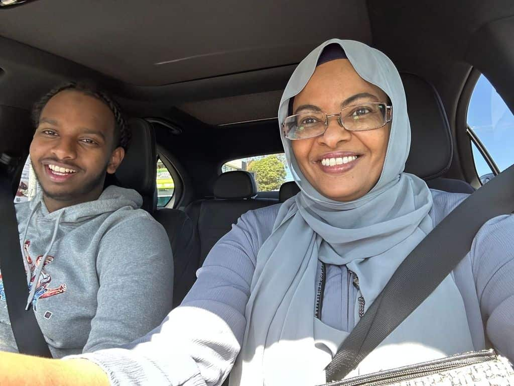 A man and a woman in the front seat of a car