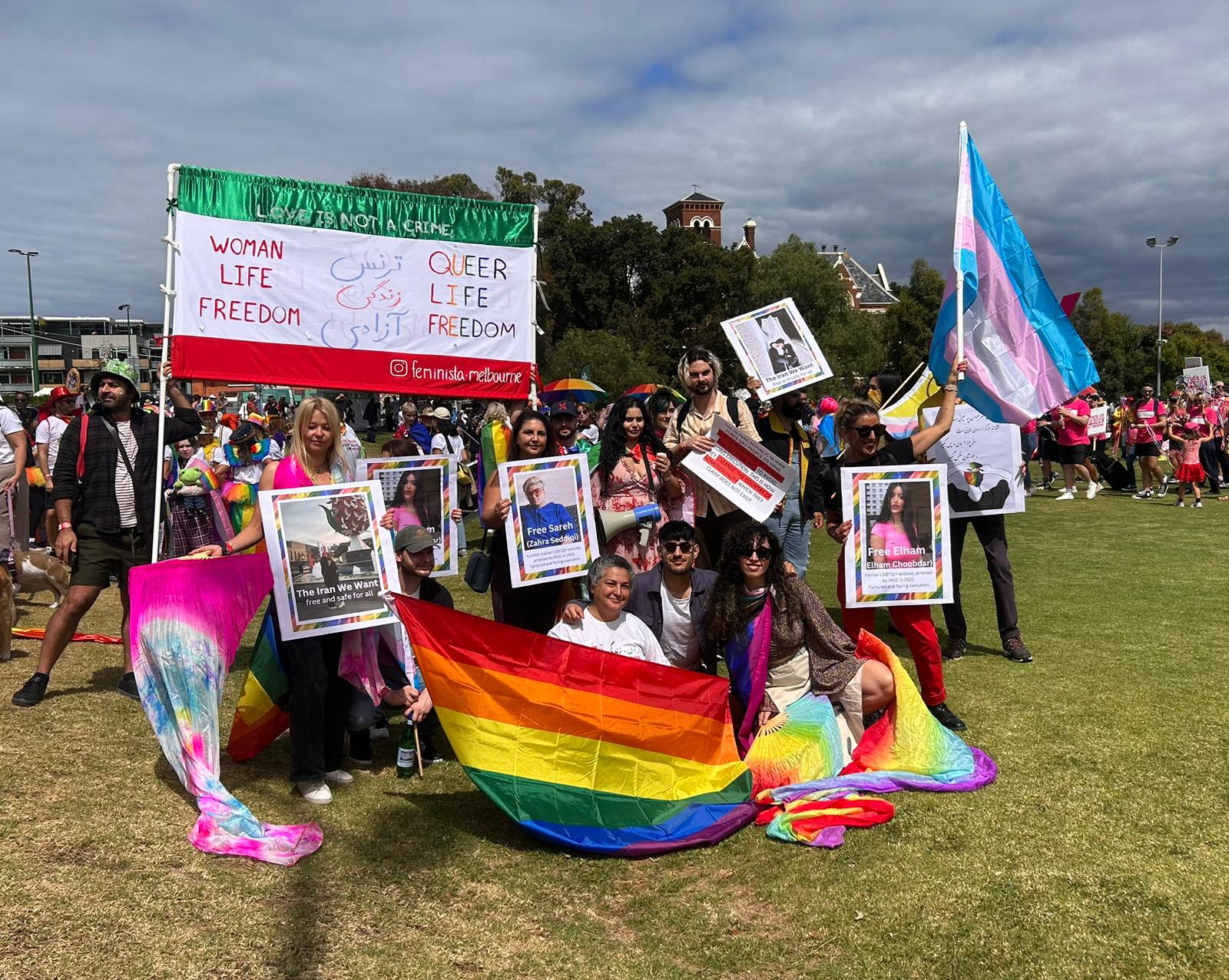 People gather together with pride flags and posters. 