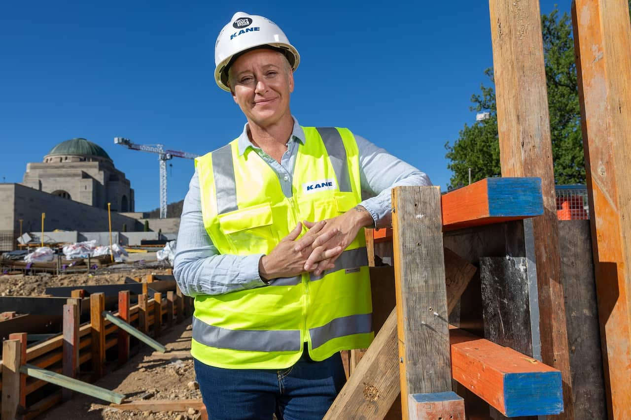 A woman wearing hi vis and a hardhat in a construction area.