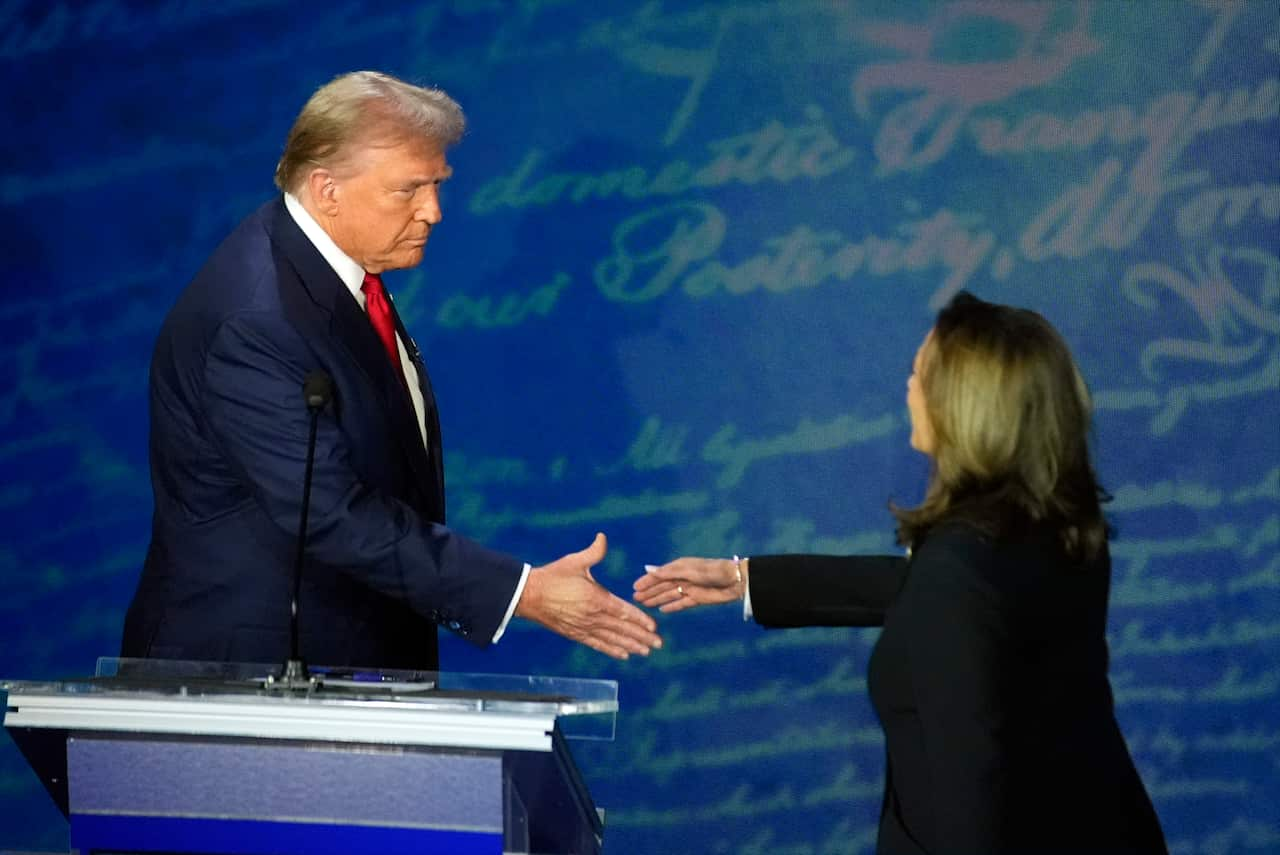 Kamala Harris and Donald Trump about to shake hands.