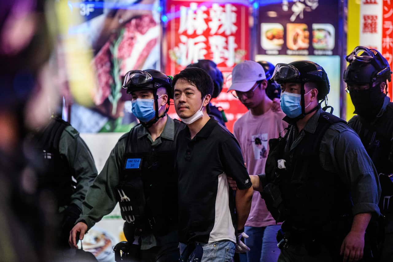 A man is detained by police officers.