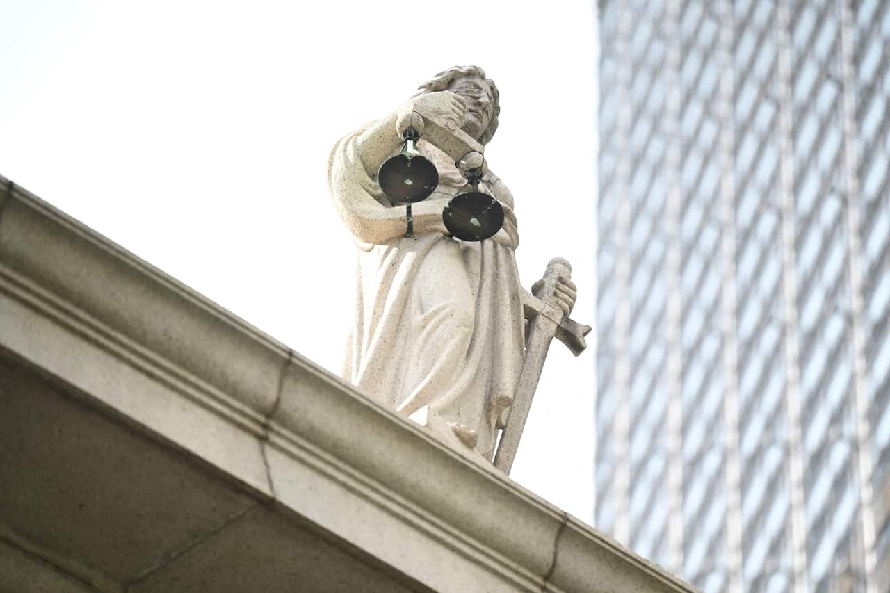 A statue of the scales of justice perched atop of a building. 