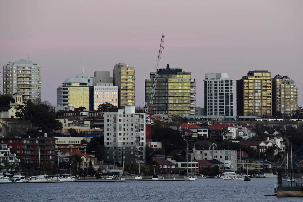 Waterfront homes with apartment buildings in the background.