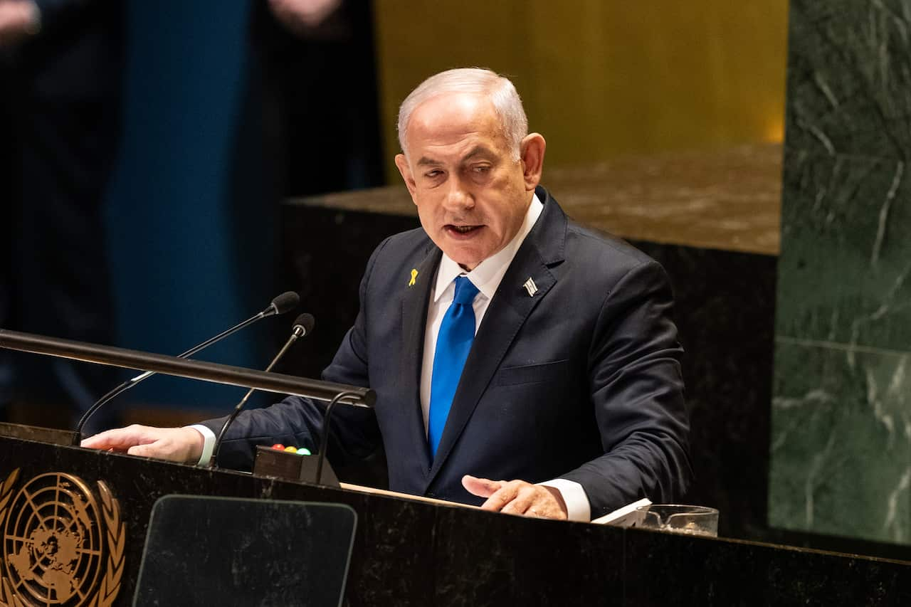 A man speaks at a lectern. 