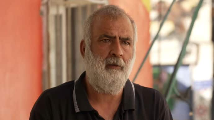 An elderly man wearing a black t-shirt.