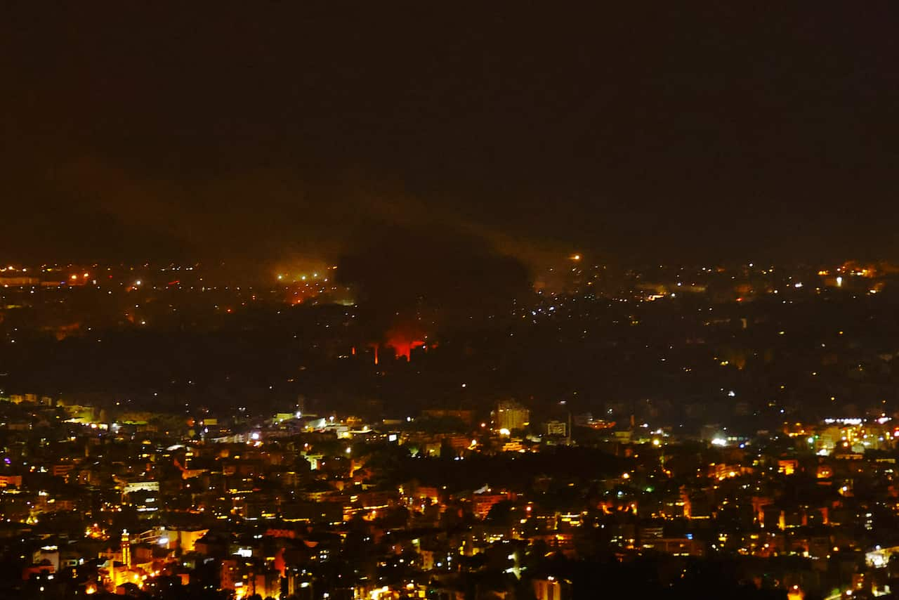 City skyline at night glowing red and orange.