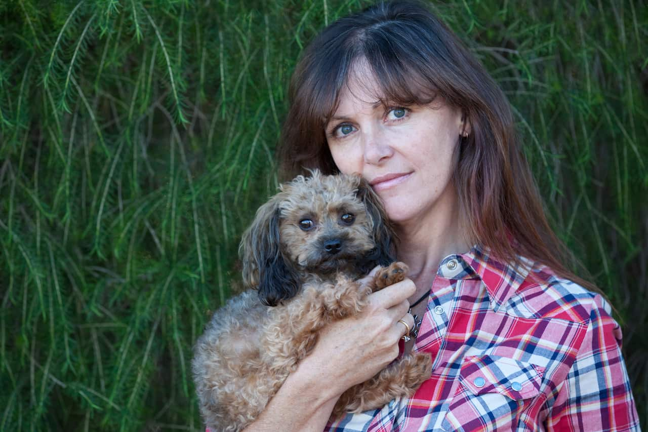 A woman holding a small dog