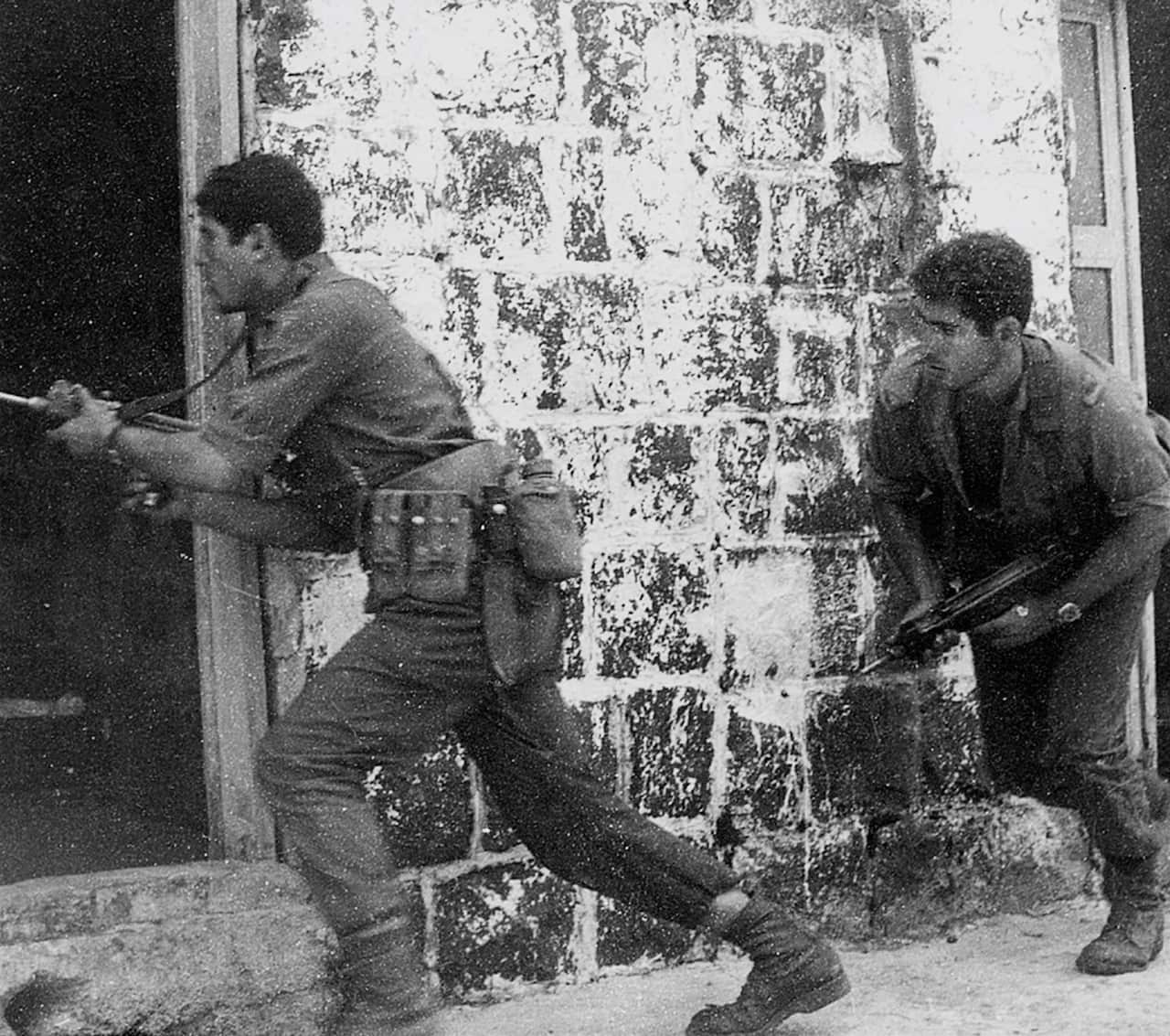 A black and white photo of two soldiers holding guns.